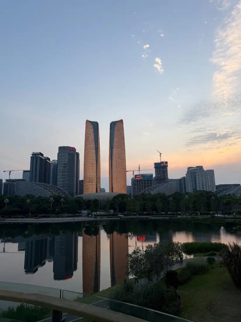 Jiaozi Park al atardecer, con el skyline moderno de Chengdu reflejado en el agua.